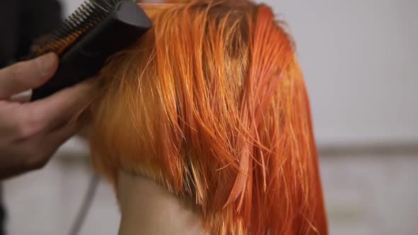 Closeup View of Professional Hair Dresser Using a Hairdryer After Haircut