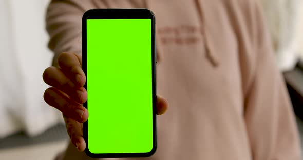 Woman Shows Smartphone with Green Screen