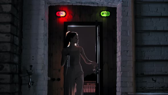 Attractive Woman Walks Out the Locker Room Holding a Bottle of Water