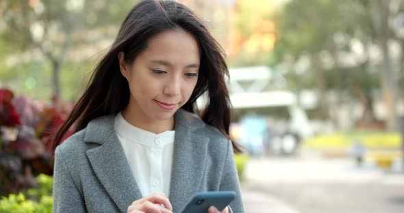 Asian Business woman look at smart phone in city