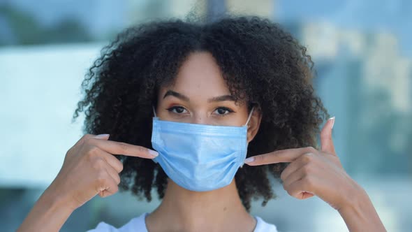 Beautiful Smiling Young African Woman Shows with Two Fingers Wearing Mask To Protect Against