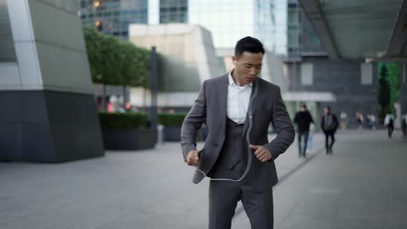 Real Time Portrait Shot of a Young Businessman Dancing with Headphones on the Street During a Break