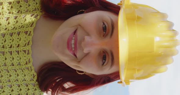 Vertical video of an engineer girl smiling with a yellow helmet