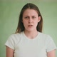 Worried Woman in White Tshirt Looks Into Camera on Green - VideoHive Item for Sale