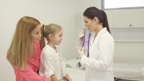 Professional Female Doctor Checks Heartbeat and Lungs Using Stethoscope During Coronavirus Epidemic