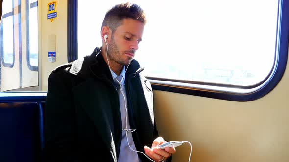 Businessman listening to music while having coffee