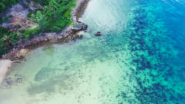 Colorful seabed on shoreline of tropical island with coral reefs under turquoise water washing rocky