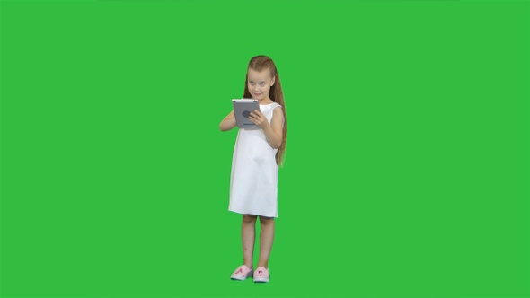 Small girl with tablet computer on a Green Screen, Chroma Key