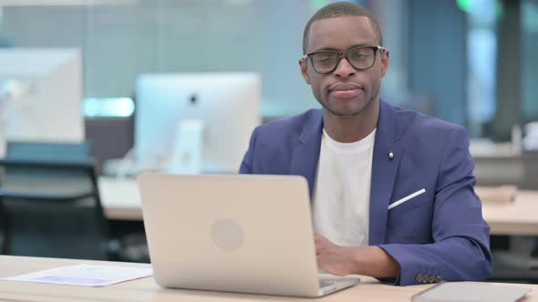 African Businessman with Laptop Smiling at Camera