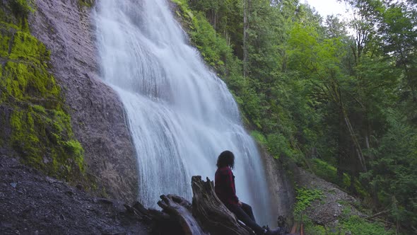 Woman Watching the Waterfall in the Canadian Rainforest