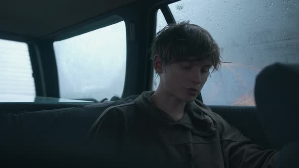 Hipsterlooking Young Man Sits in a Car in the Rain and Gives an Interview Into the Lavalier