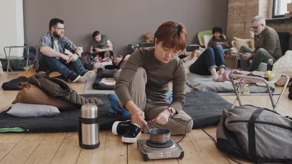 Woman Making Food in Shelter