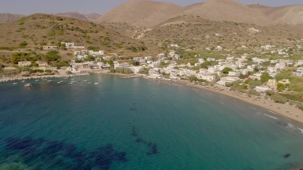 Aerial view of large white villas in front of beach at Ydroussa, Andros island.