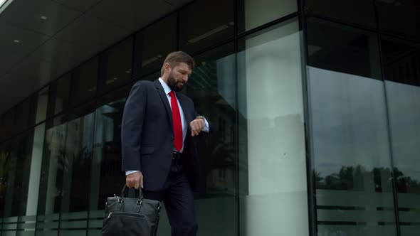 Senior Businessman in an Expensive Suit with a Briefcase in His Hand Walks Along the City Street at