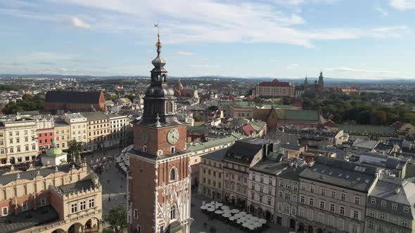 Aerial drone view of the clock tower in Krakow's main square and old city in the background at sunny