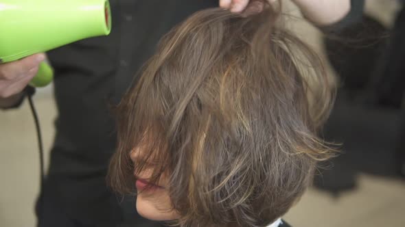 Professional Hair Dresser Using a Hairdryer After Haircut