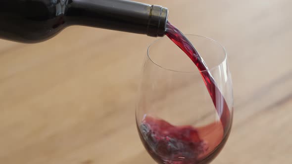 Red wine is poured from bottle into glass