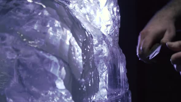 Close Up of an Artist Carving the Ice with a Knife to Make a Sculpture