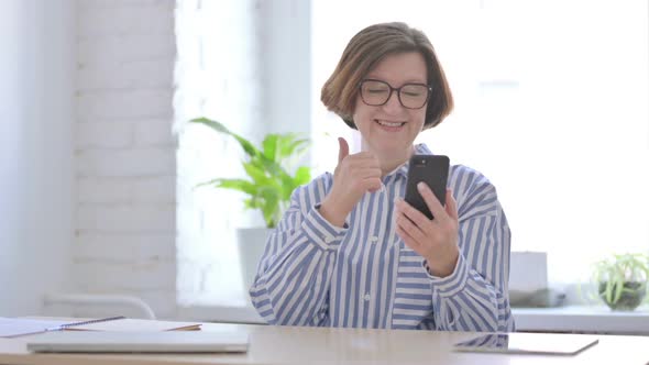 Successful Senior Woman Celebrating on Smartphone