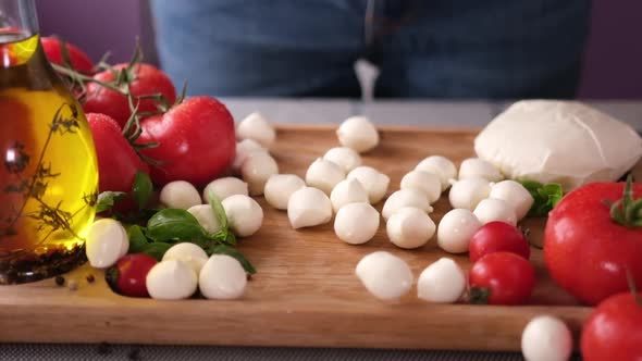 Mozzarella Cheese Small Balls Falling on Wooden Cutting Board