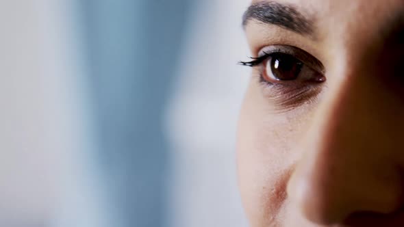 Hand of male doctor examining female patient eyes