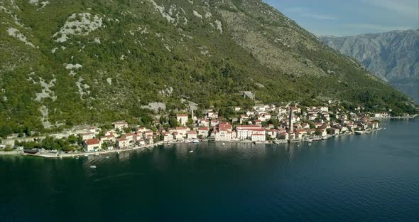 Aerial footage of Perast in Montenegro on the Bay of Kotor. The camera slowly reveals the mountains