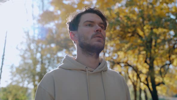 Man Doing Exercises and Stretching Before Morning Run at the Park in Autumn