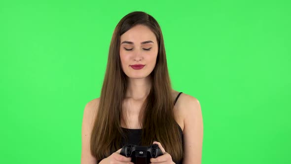 Girl Playing a Video Game Using Wireless Controller. Green Screen