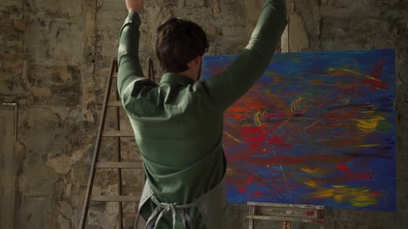 Male Artist Rejoices at the End of the Work Raising His Hands Up