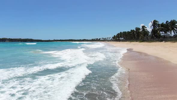 Light Blue Water is Foaming in Waves on the Beach with White Sand Tropical