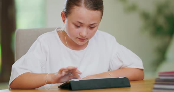 Closeup Focused Teen Girl at the Desk Scrolling Tablet First Plan and Backgroung are Blurred