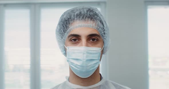 The Doctor's Face of in a Medical Mask and Cap Closeup