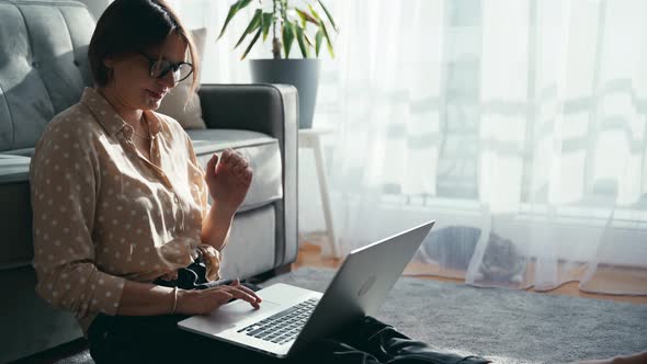 A Beautiful Middleaged Woman in Glasses Working on Her Laptop