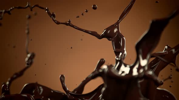 Super Slow Motion Shot of Splashing Melted Chocolate on Brown Gradient Background at 1000 Fps