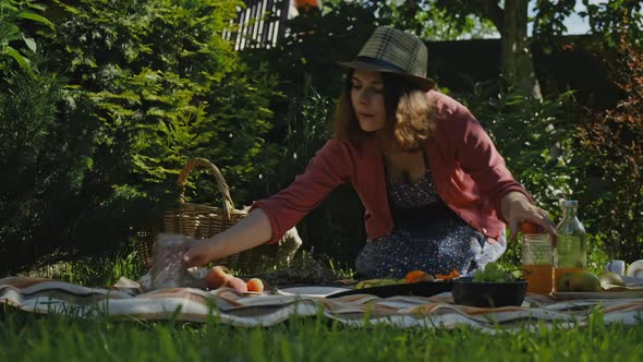 Young Woman Having Summer Picnic in Backyard