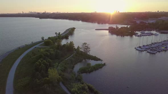 Aerial Sunset Wide Shot Of Park Slides Left Pans Right Toward Sailboat Marina Yacht Club Dock In Lak