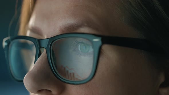 Woman in Glasses Looking on the Monitor and and Working with Charts and Analytics