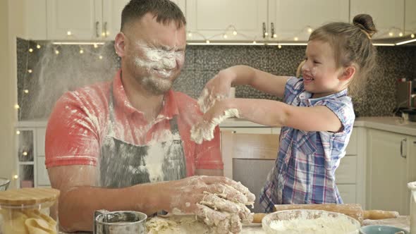 Cheerful Married Couple with a Little Daughter, Cook Some Dough Together, Enjoy Family Activities.