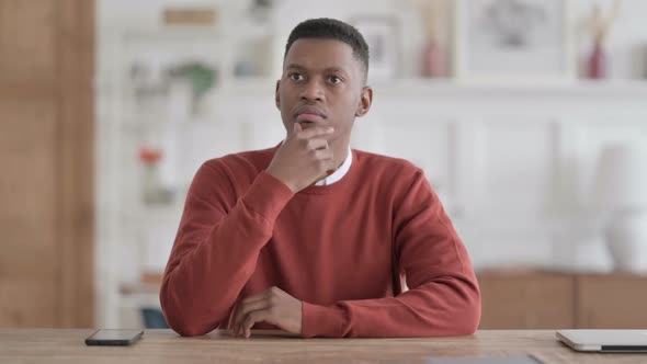 Pensive African Man Thinking While Sitting in Office