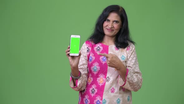 Mature Beautiful Indian Woman Showing Phone and Pointing Finger