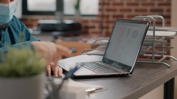 Close Up of Employee Working with Laptop and Charts Files