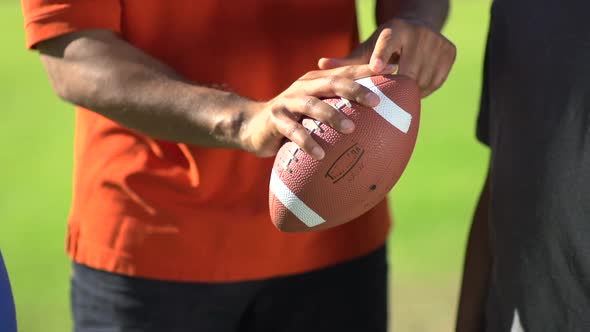 A father teaching his sons how to play American football