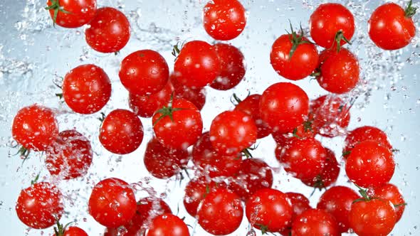 Super Slow Motion Shot of Flying Fresh Cherry Tomatoes and Water Side Splash at 1000 Fps