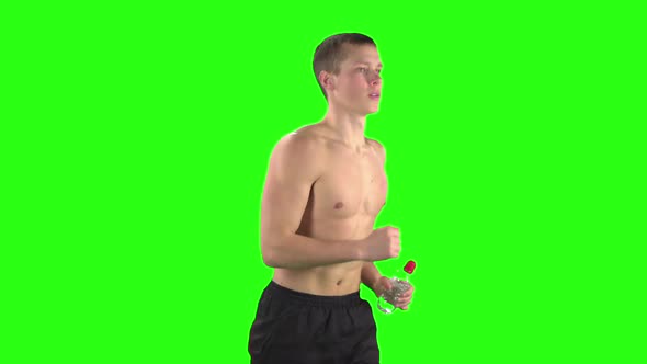 Athlete in Shorts and a Bottle of Water During Training. Green Screen. Slow Motion