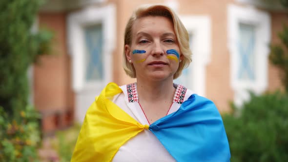 Confident Ukrainian Woman Gesturing Peace Standing on Backyard in Ukrainian Flag with Blue and