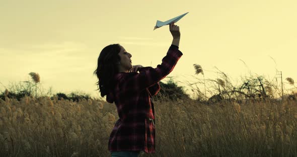 Young girl with paper airplane enjoying life 