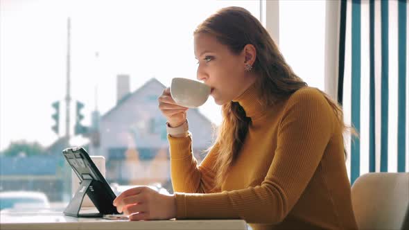 Beautiful Sunny Day Young Woman Drinks Morning Coffee in a Cafe, Making Online a Purchase Easy