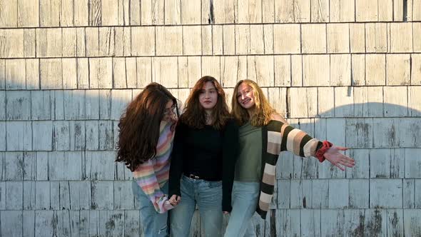 Portrait of three teen sisters goofing off for camera