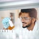 Young Smiling Student in White Coat Doing Chemical Tasks - VideoHive Item for Sale