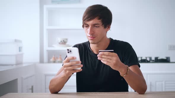 Young Man Online Banking Using Smartphone Shopping Online with Credit Card at Home